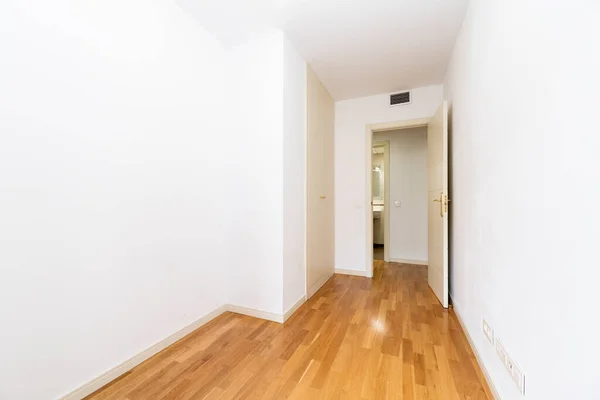 白い木製のワードローブのドアとダクト付きの空のベッドルームエアコン 白い塗装壁と木製の床 — ストック写真