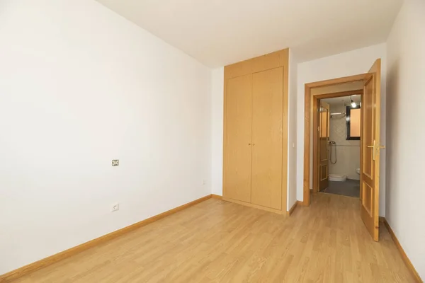 オーク色の木製の組み込みのワードローブと空の部屋マッチングフローリングと平らな白い壁 — ストック写真