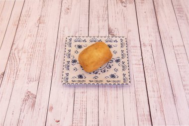 Mavi desenli porselen tabakta büyük bir İtalyan usulü kızarmış kroket.