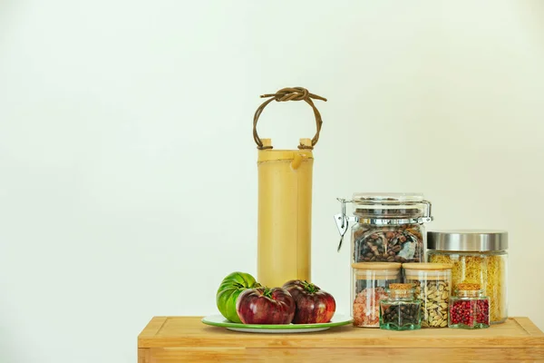 不同大小的玻璃瓶 盛满调味品 调味品 汤糊和咖啡豆 竹壶和一些美味的西红柿 — 图库照片