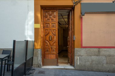 Eski bir apartmanın kapı tokmağı ve pirinç saplı küçük tahta kapı.