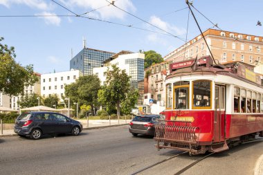 Portekiz 'in eski Lizbon kentindeki şehir trafiğinde raylarında klasik kırmızı tramvay var.