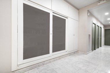 Beyaz ahşap ve mermer zeminli sürgülü cam kapılı gardırop.