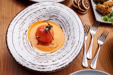 Tahta masalı bir restoranda servis edilen lezzetli bir domates tarifi.