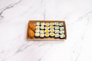 Avokado, salatalık ve kızarmış kroket dolu ev yapımı suşi tepsisi.