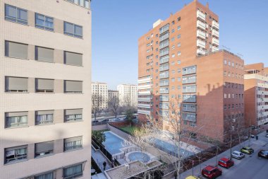 Avlularda yüzme havuzları ve ortak dinlenme alanları olan vahşi mimari binaların kentsel konut manzaraları