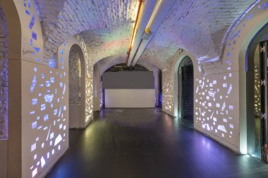 Kurşunlu ışıkları ve beyaz tuğlalı tavanı olan bir gece kulübünün boş odası.