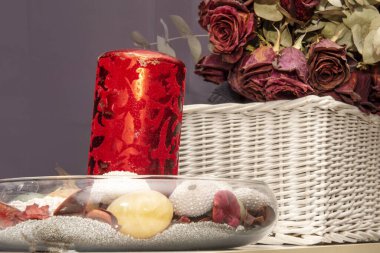 Decorative details of a living room with a centerpiece with sand and shells and a bouquet of dried roses