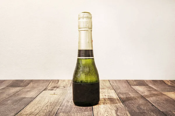 A small bottle of Spanish cava on a wooden table