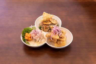 Ceviche is a Peruvian dish made from fresh raw fish cured in citrus juices. It is seasoned with chiles, chilli peppers or other seasonings, and julienned red onion, salt and cilantro are added