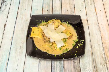 Ravioli are an Italian stuffed pasta made with different ingredients and usually folded into a square shape.