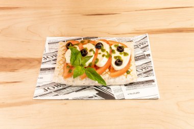 Caprese, is an Italian salad composed of slices of tomato and fresh mozzarella, and fresh basil leaves, of the large leaf and super leaf variety, drizzled with olive oil