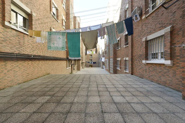 Interior patio between buildings that the neighbors use as clothes lines with sliding ropes