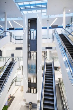 Escalator and elevator with hydraulic system in atrium with skylights
