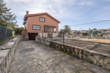 Access ramp to the garage with a stone floor in a building with a three-story house and an attic