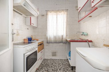 dilapidated kitchen front with tiles and old appliances