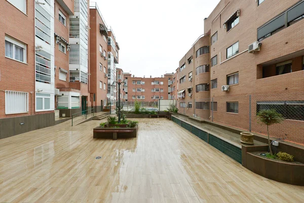 Interior common areas of an interior block patio in an urban residential housing development on a rainy day