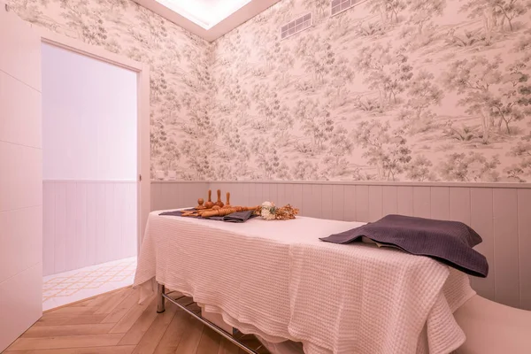 Cabin with massage table with towels and wood therapy utensils and treatments from a beauty salon and aesthetic care