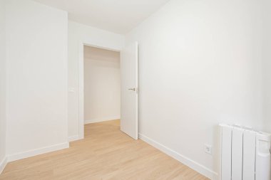 Empty room painted white with woodwork of the same color