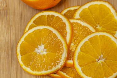 A pile of fresh orange slices on a wooden board