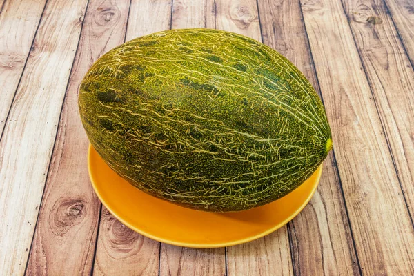 A wonderful piel de sapo melon on a yellow plate
