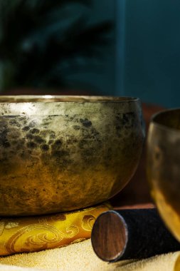 Tibetan metal bowls for the ritual of relaxing massages on a table with towels
