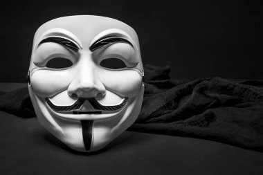 A mask of those used by the anonymous with a black cloth and a black background
