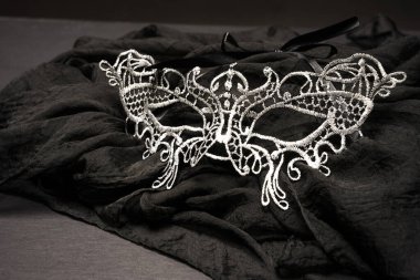 Silver organdy mask on a black cloth