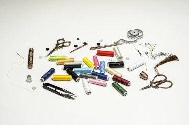 Sewing still life with spools of colored threads on white background