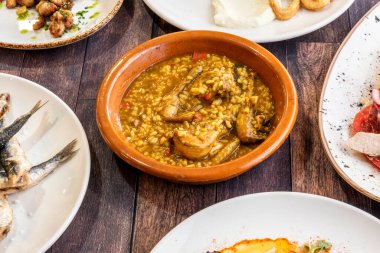 Set of typical Spanish food dishes with known recipes, rice stew with partridge, fried anchovies