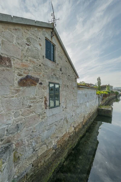 Facade of a beautiful stone building on the edge of a river in Galicia, Spain