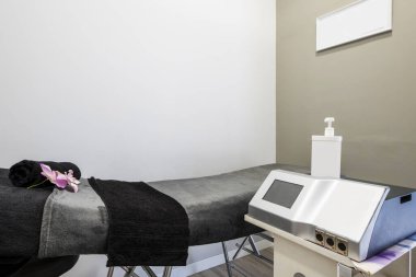 Terapi amaçlı masaj uygulamak için elektronik aletlerle bir güzellik kliniğinde tedavi kabini.