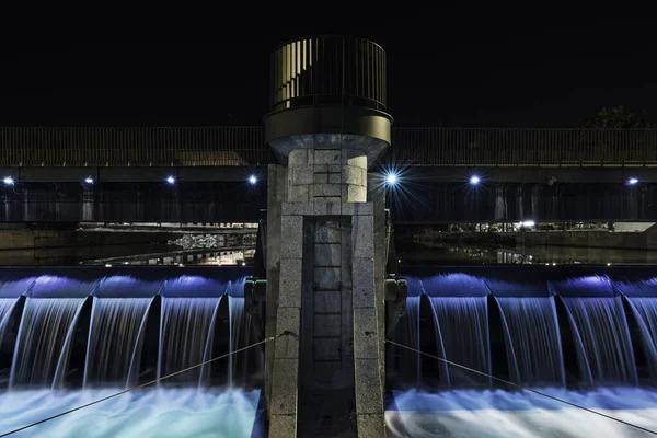 在马德里曼萨纳雷斯河的一个小水库里 有一条带金属栏杆的石道 水从那里流下的夜间图像 — 图库照片