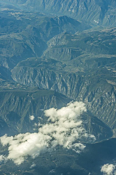Aerial image of low clouds over heavily vegetated mountaintops