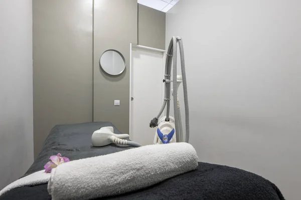 stock image Aesthetic medicine treatment cabin with a stretcher with a blanket, electric devices to apply treatments and creams, towels and mirrors