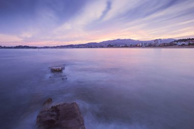 Galiçya sahillerinde yükselen gelgitin vurduğu yarım yamalak bir taş iskelenin uzun pozlama görüntüleri.