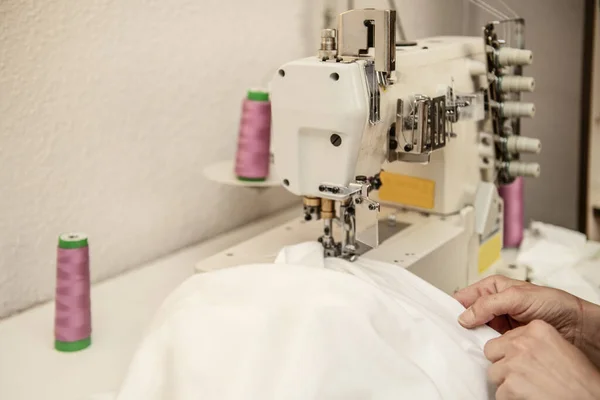 女工用电动缝纫机缝制白布的女工 — 图库照片