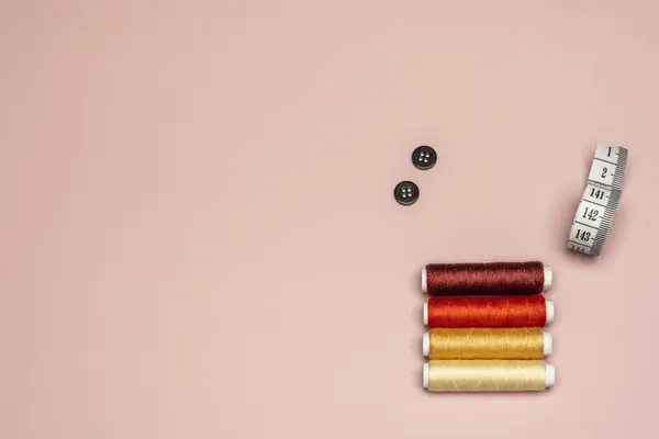 Натюрморт Кольоровими Нитками Чорними Кнопками Мірою Стрічки Звичайному Рожевому Фоні — стокове фото