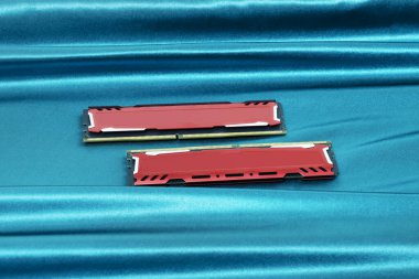 Kırmızı metalik ısıya sahip bir çift PC ddr4 bellek modülü parlak yeşil bir bez yüzeye batar