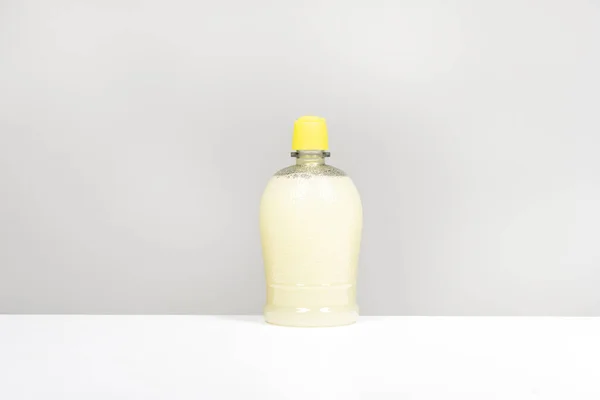 Полупрозрачная Пластиковая Бутылка Лимонным Соком Гладкой Белой Поверхности — стоковое фото