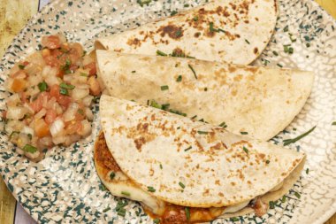 Etin eklendiği Quesadilla tüzüğüne göre ve Meksika 'nın bazı bölgelerinde gringalar et dolu bir tortilla çemberi oluşturmak için birbiri üzerine yerleştirilmiş iki tortilladır.