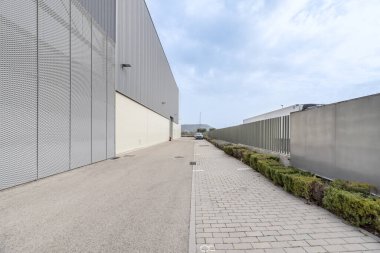 Bahçeleri ve araçlar için park yeri olan bir sanayi deposu.