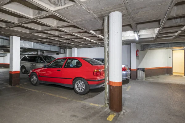 stock image A few utility vehicles parked in the parking spaces of a residential building