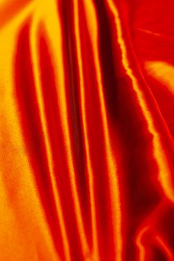 Aynı yönde birkaç kırışıklığı olan kırmızı saten bir kumaş.