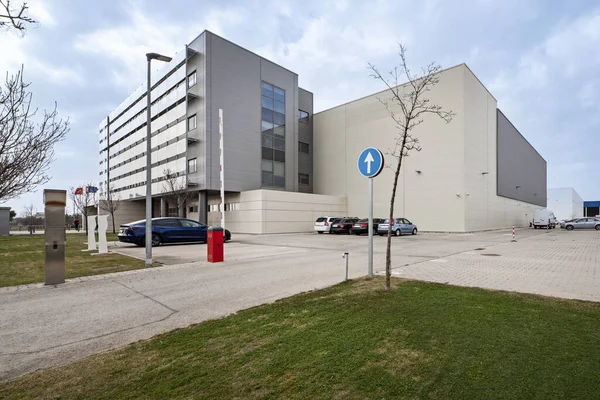 stock image Facade of an office building and a factory module in the back