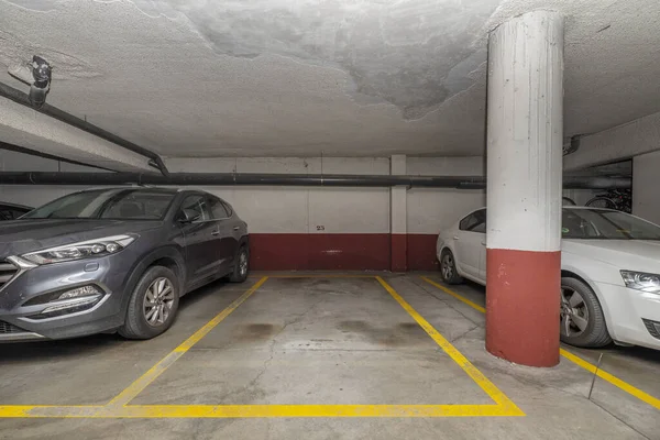 stock image Some parking spaces in an urban residential apartment building with yellow columns and boundaries