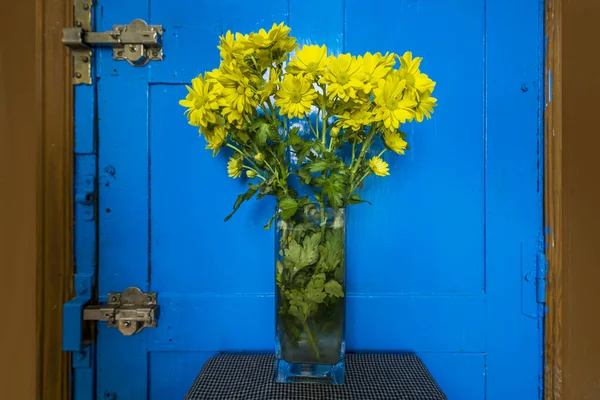 Vaso Margaridas Amarelas Lado Uma Porta Azul Brilhante — Fotografia de Stock