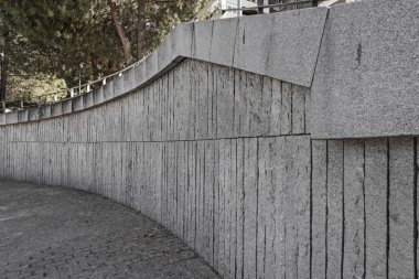 Gri granit duvar, taştan şeritler ve kaldırım taşı döşemeleri aynı malzemeden.