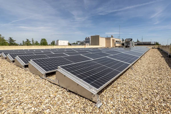 Rooftop of an office building covered in gravel with a bunch of solar panels on top