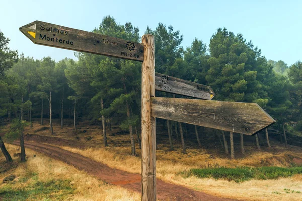 A wooden post with direction indicators on dirt roads for trekking in the mountains
